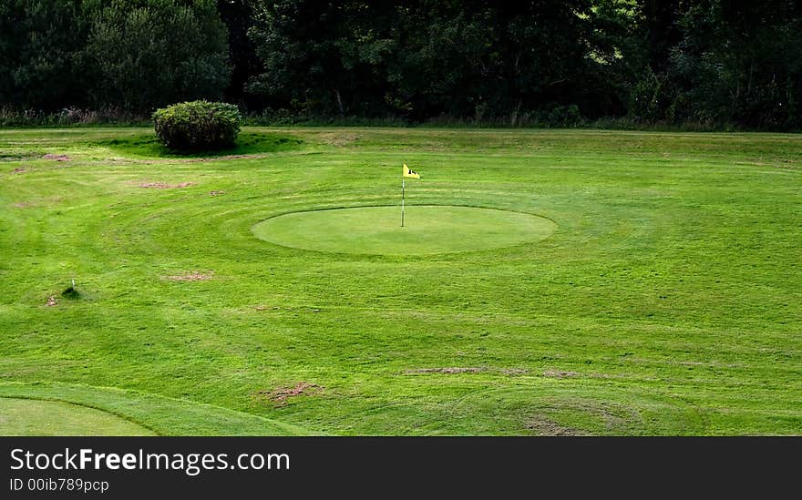 Golf field with yellow flag. Golf field with yellow flag.