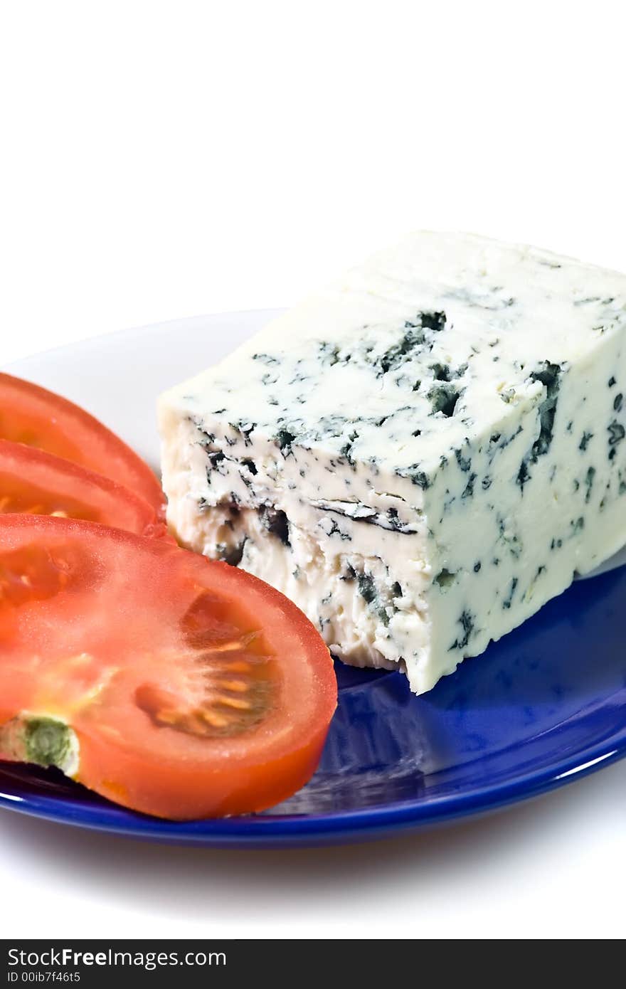 Closeup of blue cheese and tomato slices on the plate.