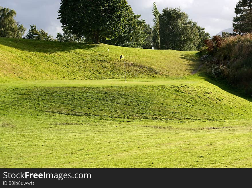 Golf field with yellow flag. Golf field with yellow flag.