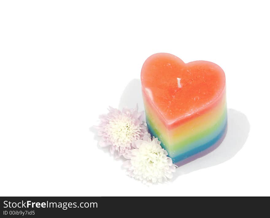 Multi coloured candle with flowers against a white background. Multi coloured candle with flowers against a white background