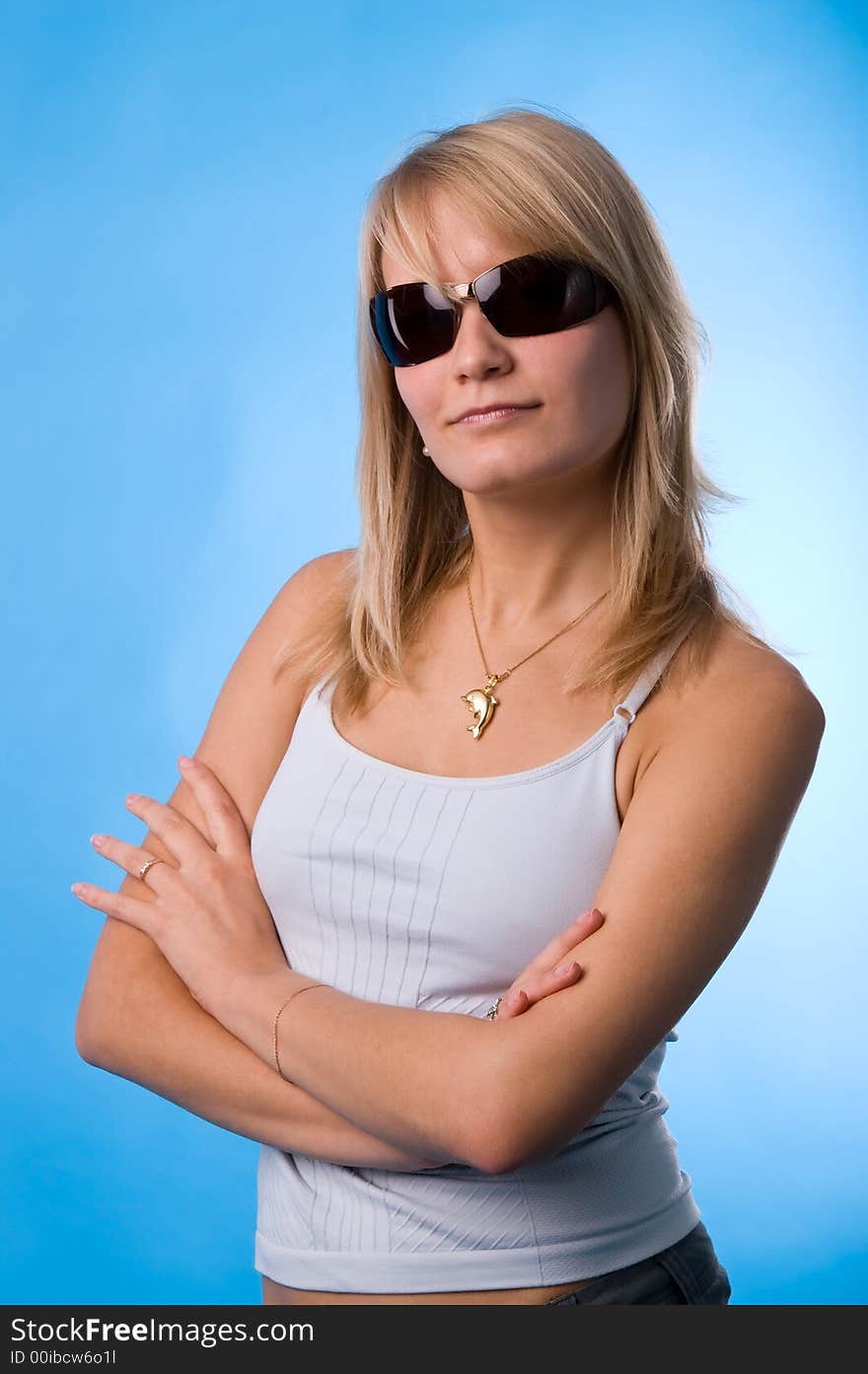 The girl in glasses on a blue background in studio