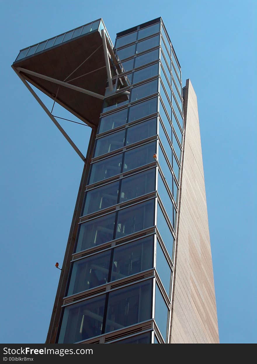 A glass observation tower against a blue sky.