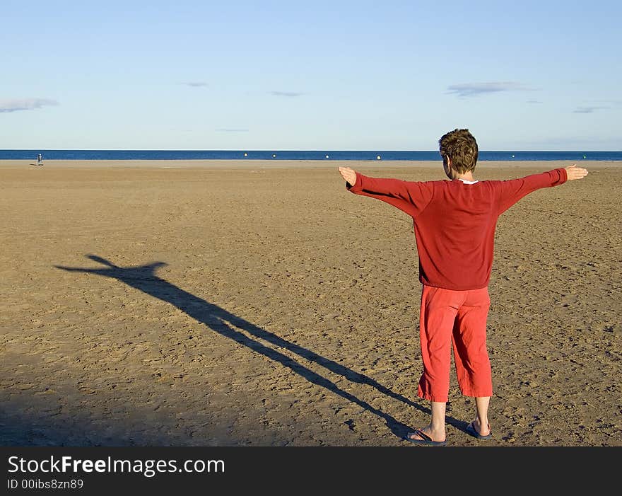 Woman in red clothes making a shadow at sunset on the beach. Woman in red clothes making a shadow at sunset on the beach