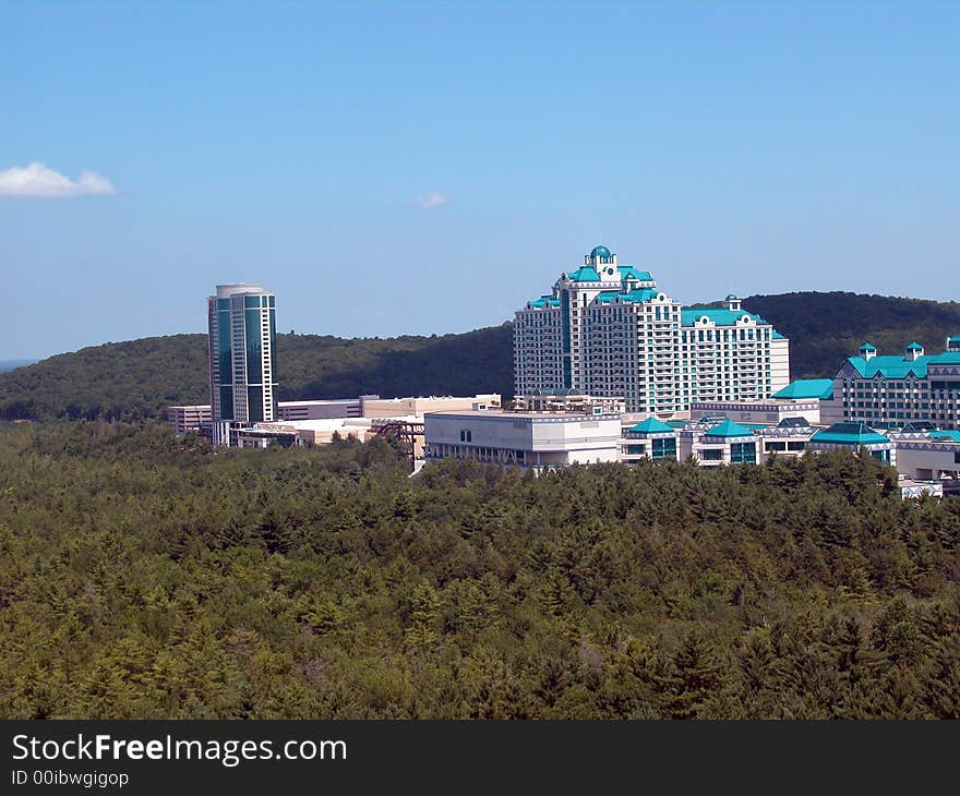 A distant resort can be seen in this arial view looking from above the trees.