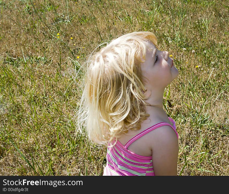 Young girl playing in a field on a warm sunny day in July. Young girl playing in a field on a warm sunny day in July.