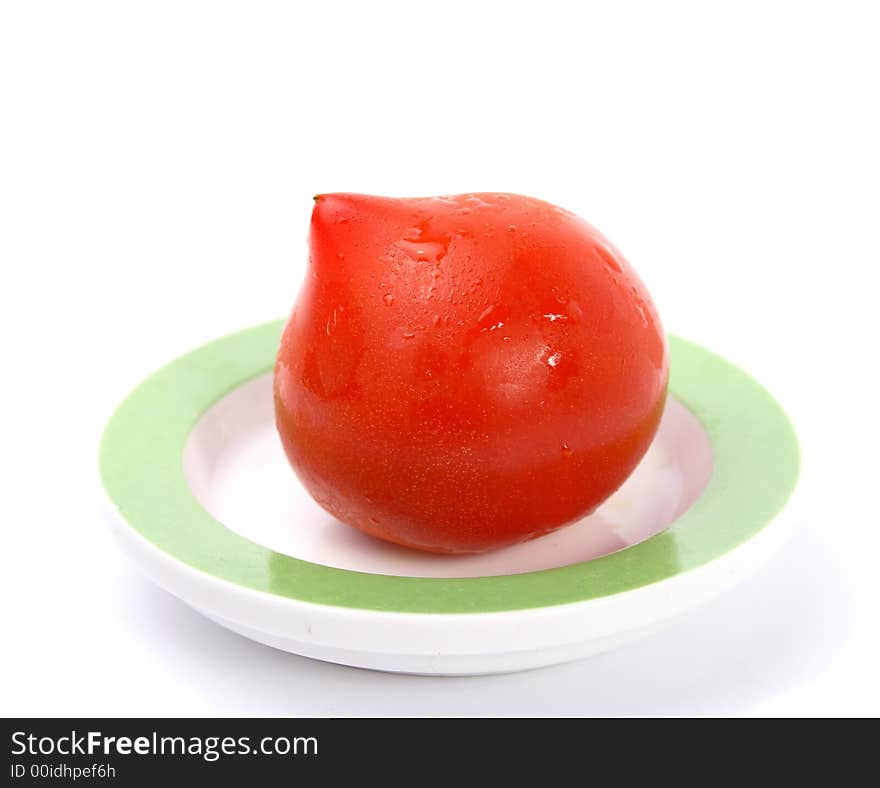 Single big red tomato on little saucer. Single big red tomato on little saucer