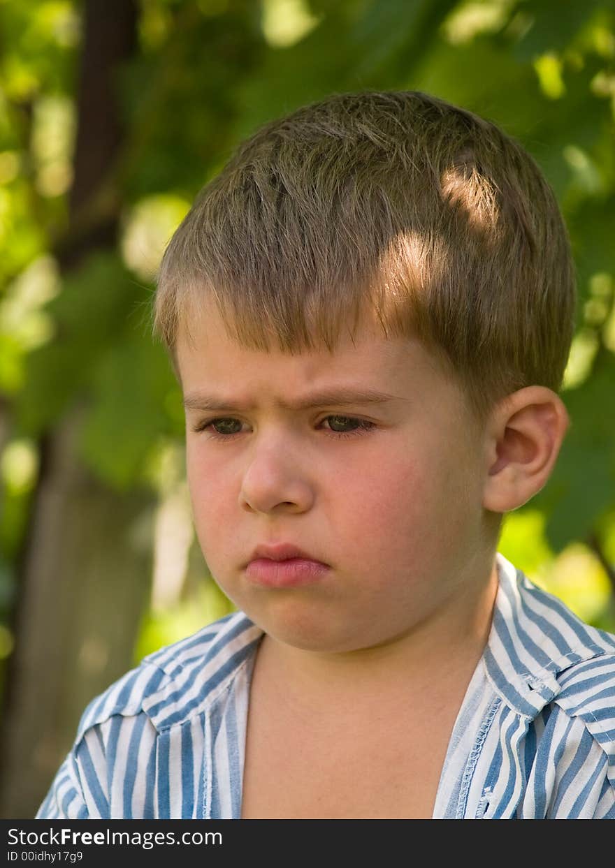 Little sadden boy portrait over bight summer background. Little sadden boy portrait over bight summer background.