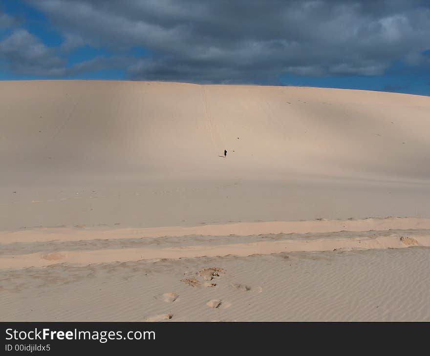 Man trekking up sand dune on Moreton Island, Australia. Man trekking up sand dune on Moreton Island, Australia