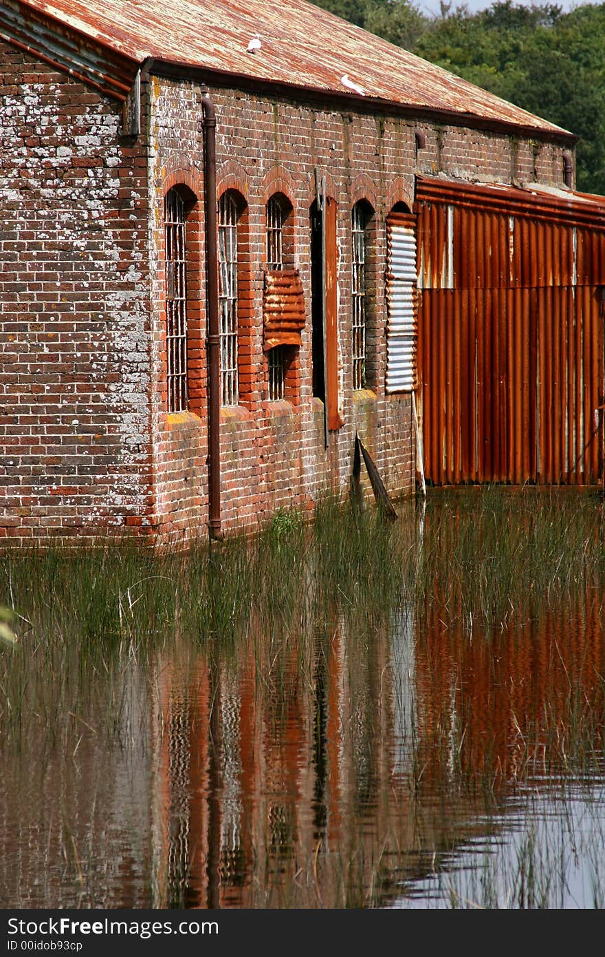 Derelict building reflected in pond. Derelict building reflected in pond