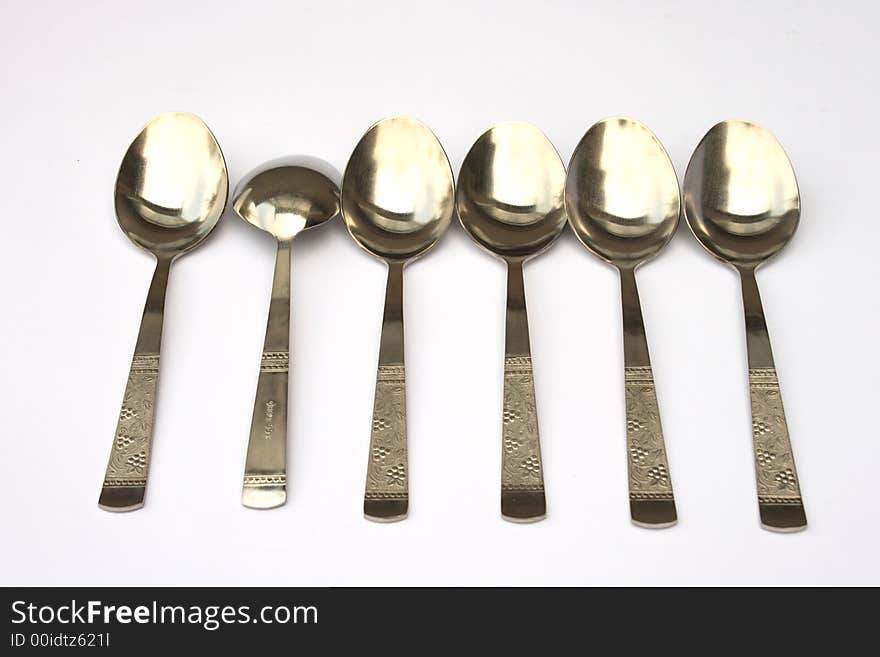 On a photo a line of spoons and one turned