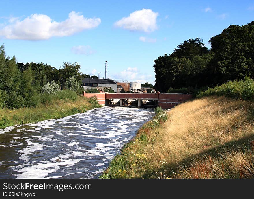 Swollen River with Sluice Gate, Bridge and Factory in the background