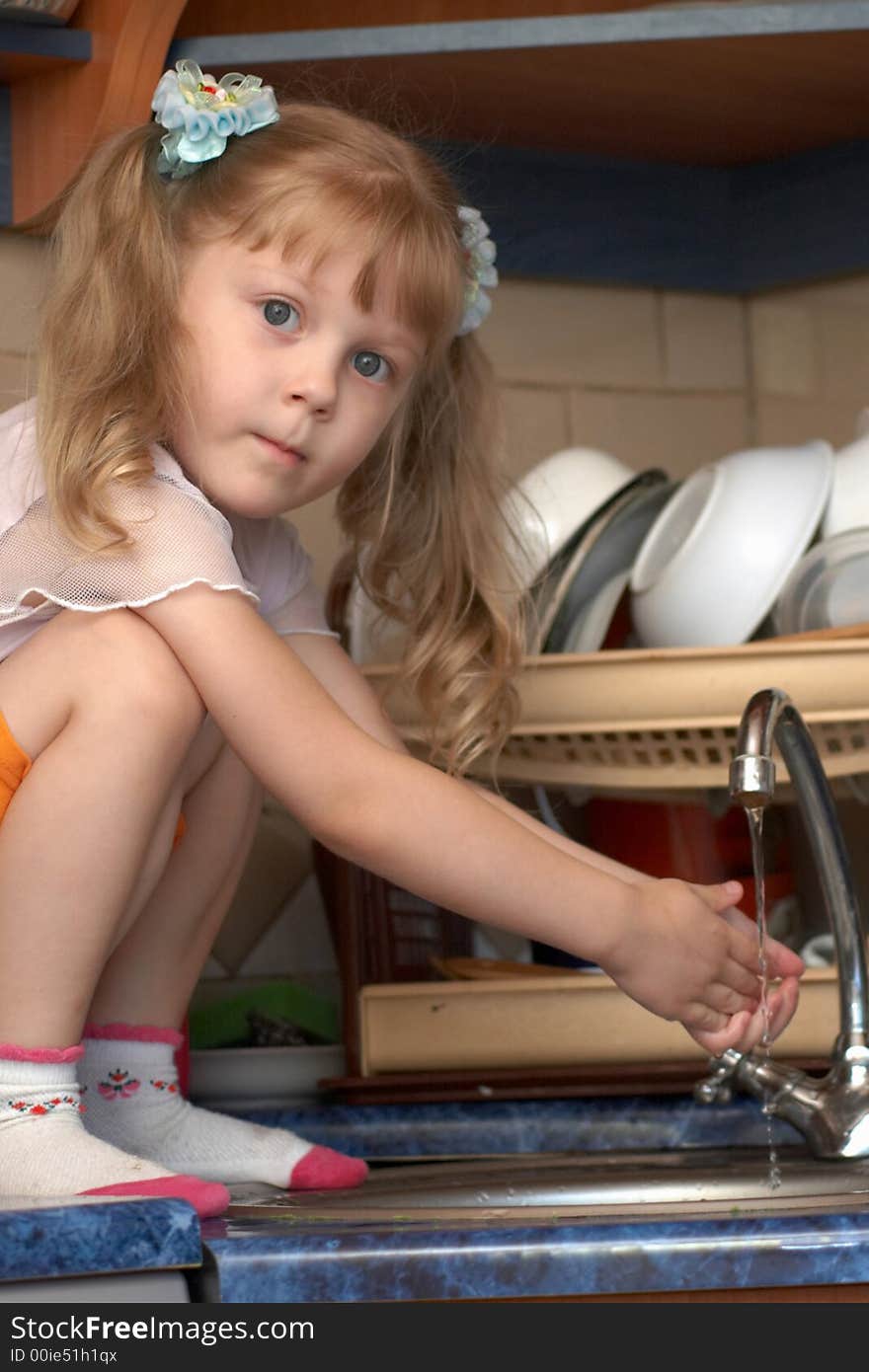 Girl helping her mother to wash dishes. Girl helping her mother to wash dishes