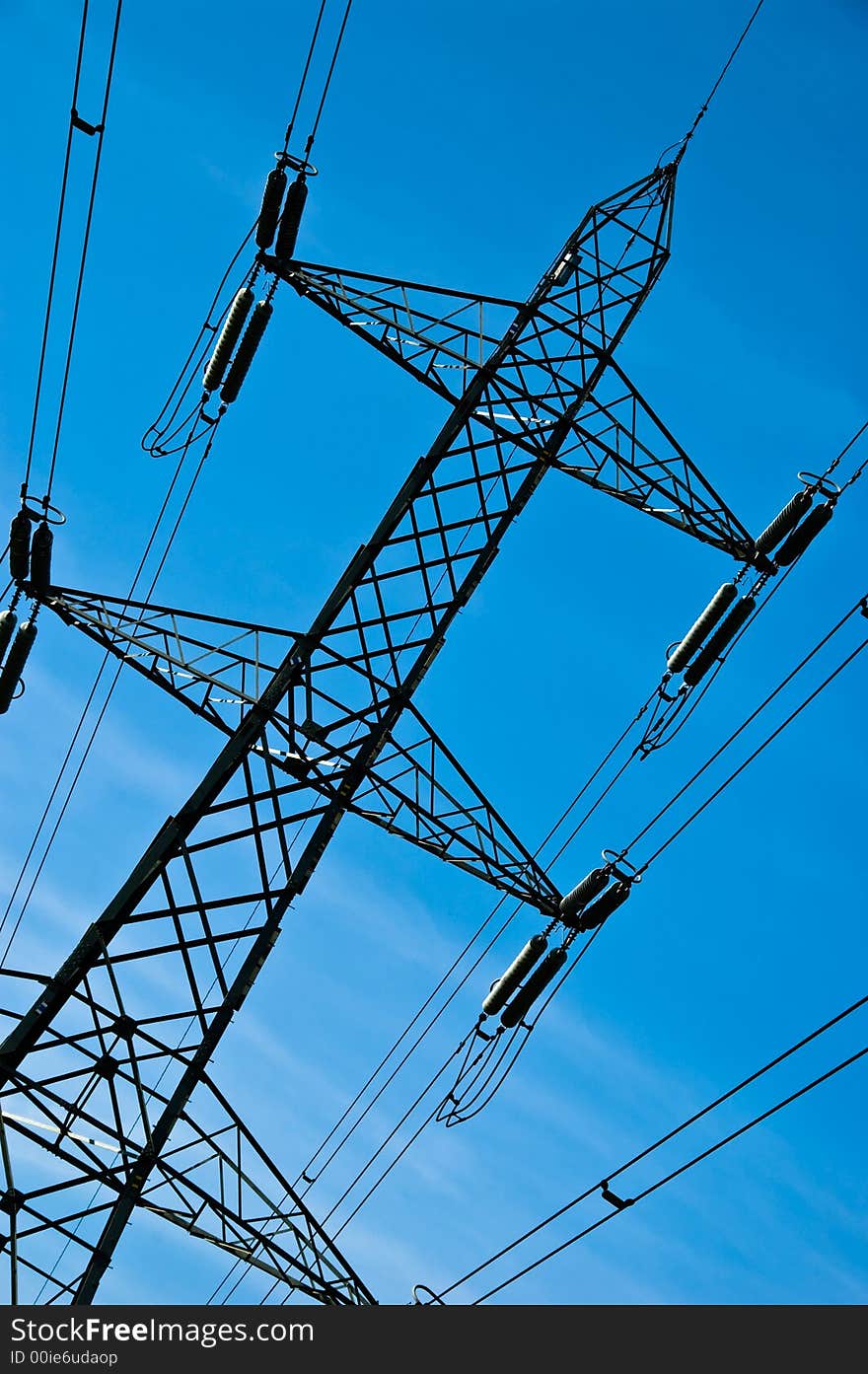 A looming electricity pylon against a blue sky. A looming electricity pylon against a blue sky