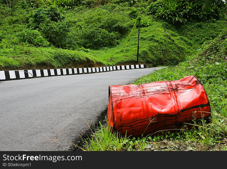 Oil barrel at roadside. Very green surrounding.