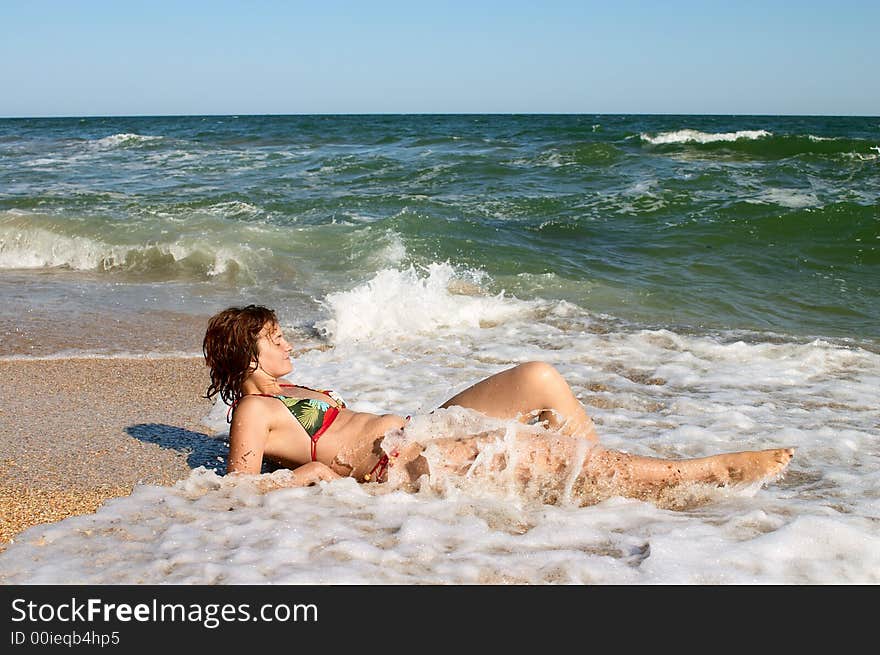 Girl sunburning in surf on the sea coast