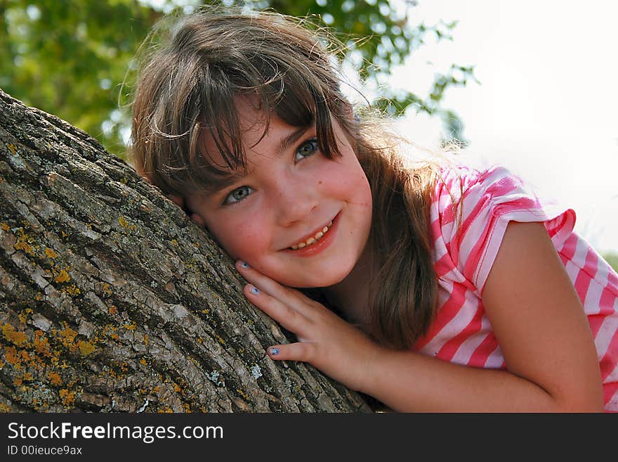 Beautiful little girl in leaning on a tree. Beautiful little girl in leaning on a tree.