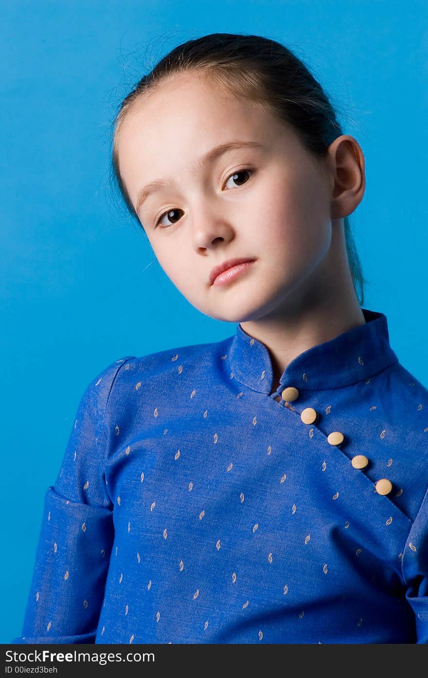 The girl of ten years in studio on a dark blue background, in the chinese dress. The girl of ten years in studio on a dark blue background, in the chinese dress.