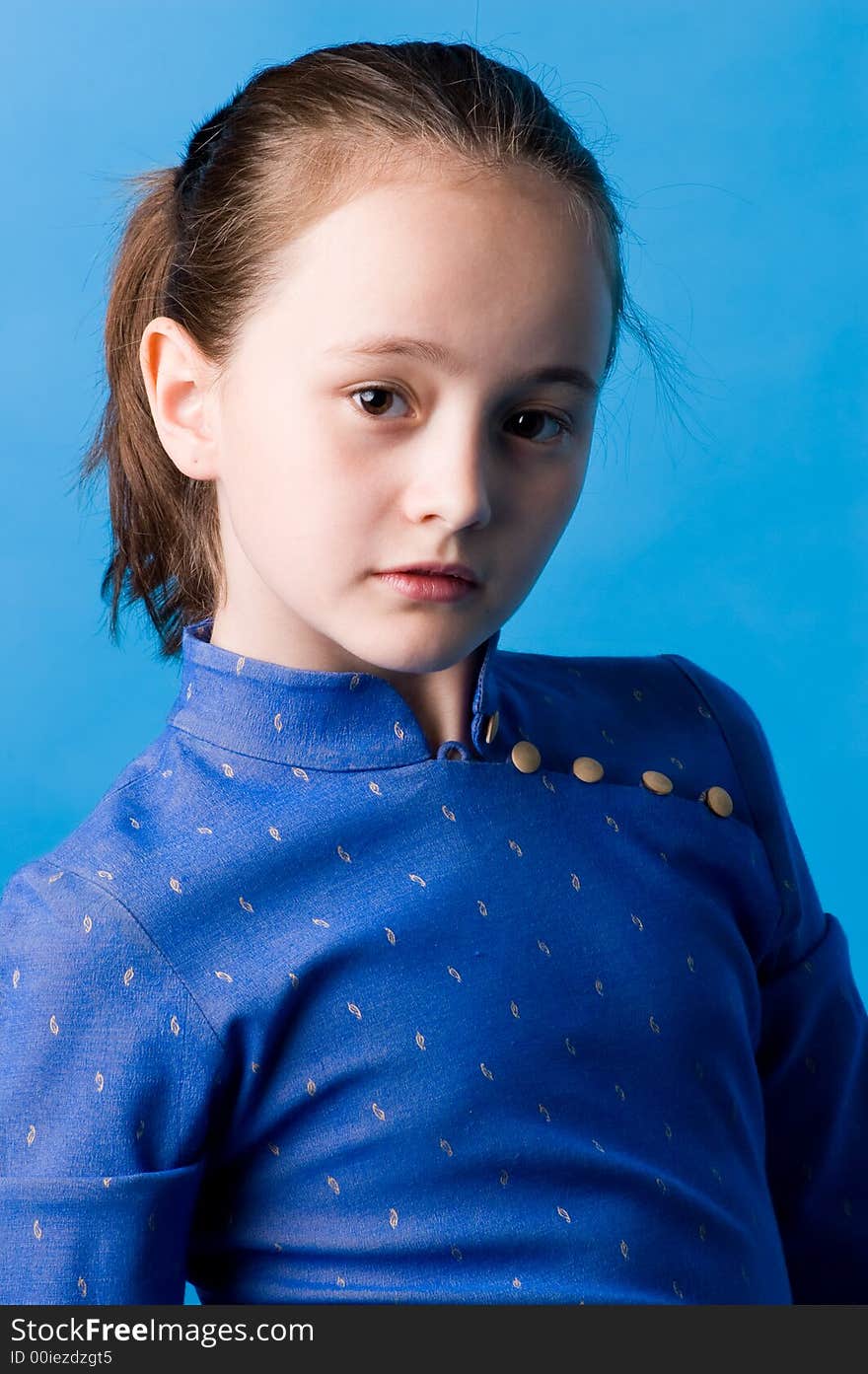 The girl of ten years in studio on a dark blue background, in the chinese dress. The girl of ten years in studio on a dark blue background, in the chinese dress.