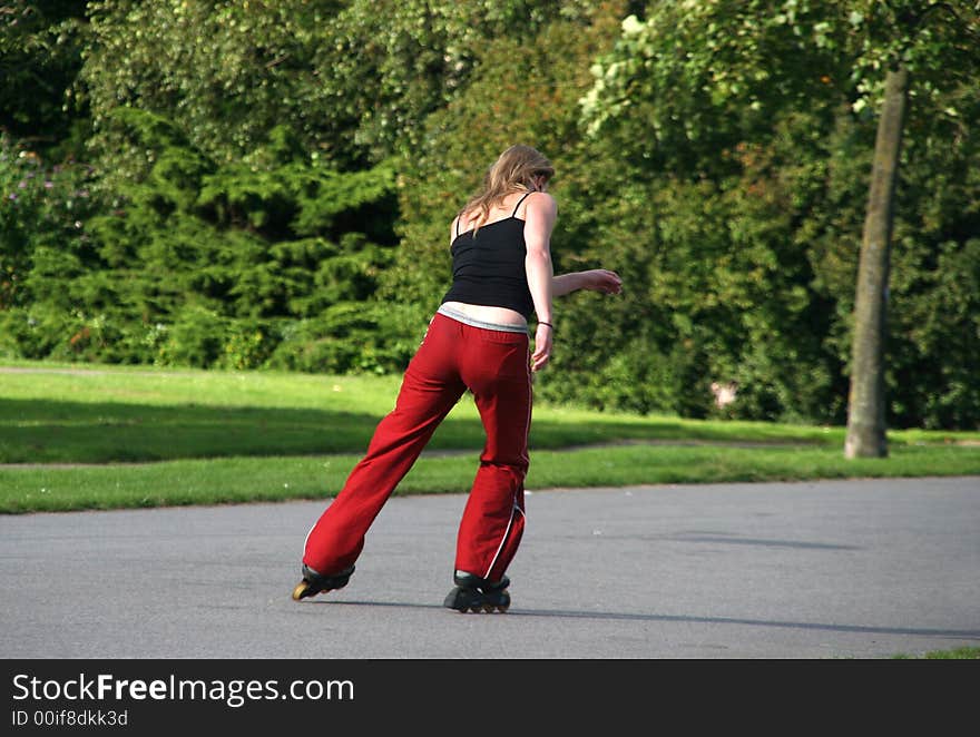 Girl riding on rollerskates in the park. Girl riding on rollerskates in the park