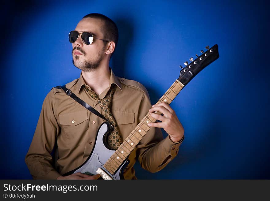 Alternative guitar player in studio, wearing sunglasses. Alternative guitar player in studio, wearing sunglasses.