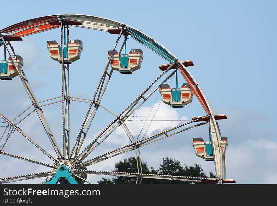 Ferris wheel against bule sky with clouds