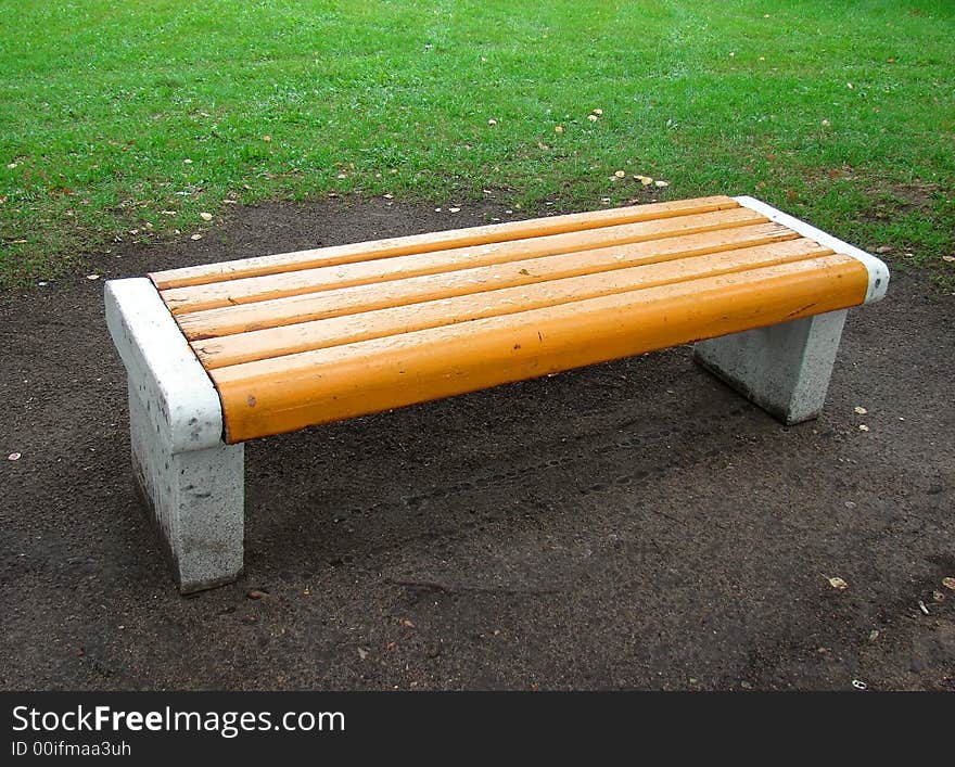 Yellow bench in park after rain