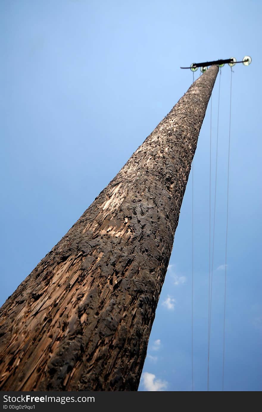 Wooden column of an electric main on  background of  sky