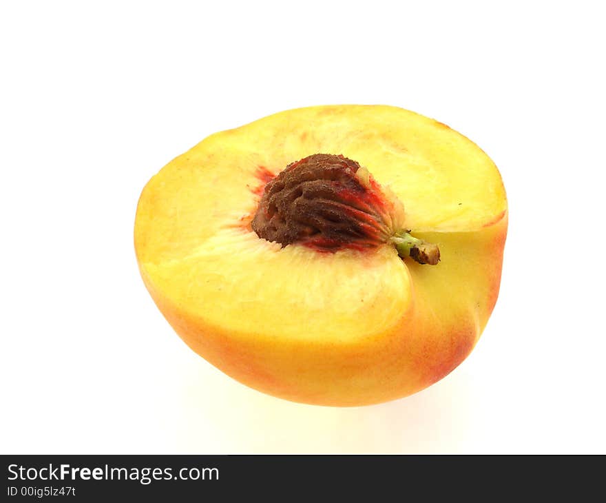 Half of peach with stone on white background