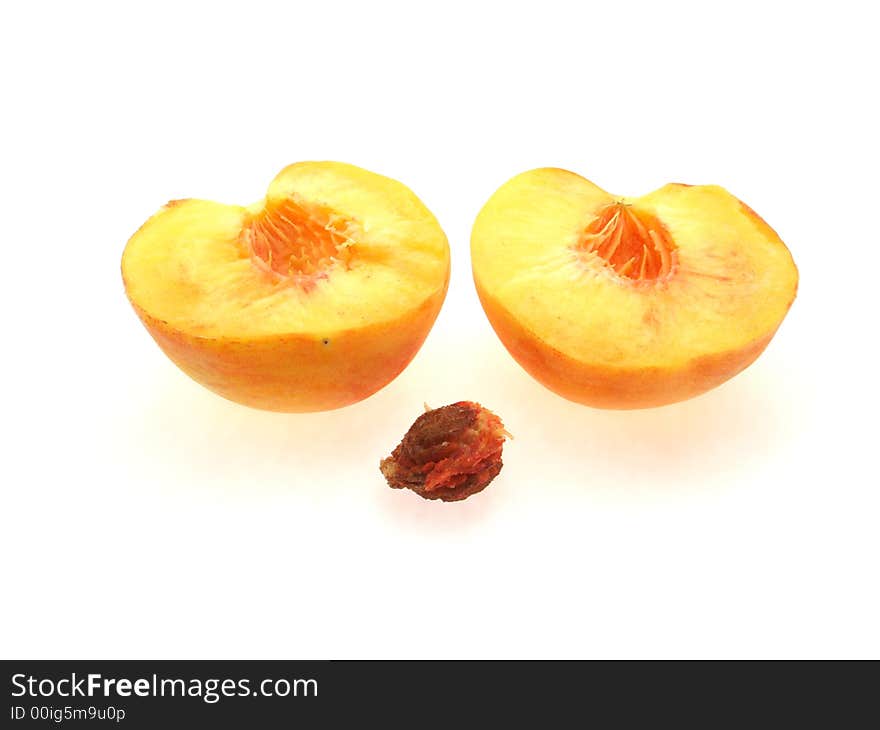 Two halfs of peach and stone on white background