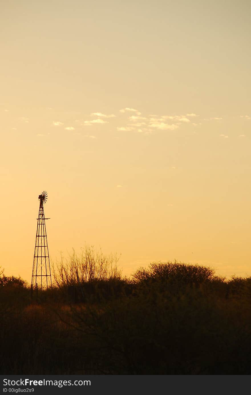 Sunset in the Kalahari desert in South Africa. Silhouette of a windpump in the foreground. Sunset in the Kalahari desert in South Africa. Silhouette of a windpump in the foreground.