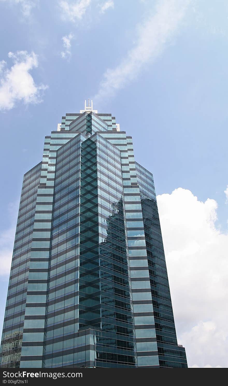 A modern blue office tower rising into the clouds. A modern blue office tower rising into the clouds