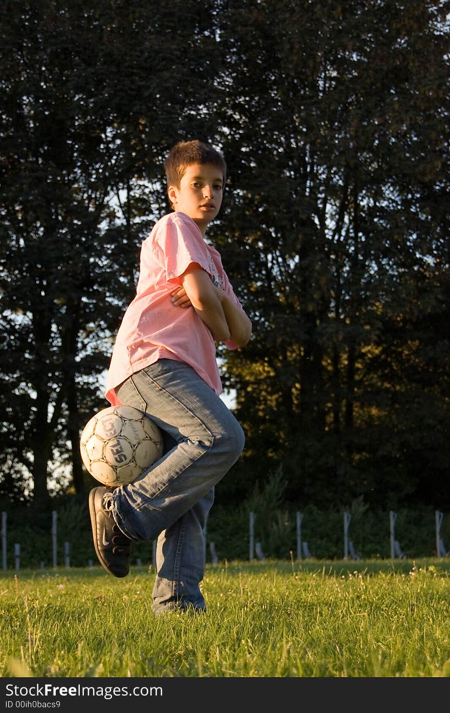 Boy holding soccerball with leg. Boy holding soccerball with leg