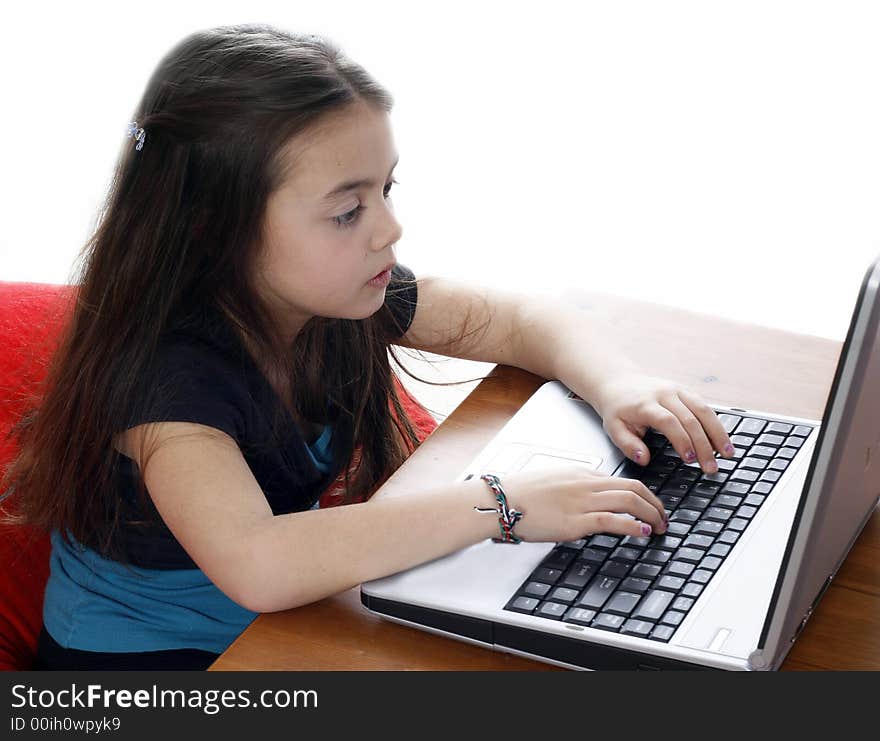 Young girl sitting down and working on a laptop. Young girl sitting down and working on a laptop