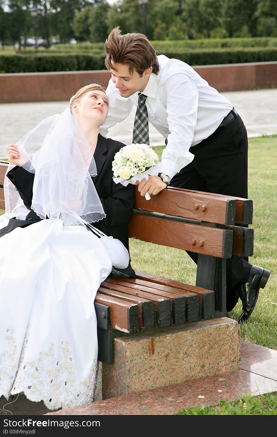 Bride sits on the bench and looks at the fiance