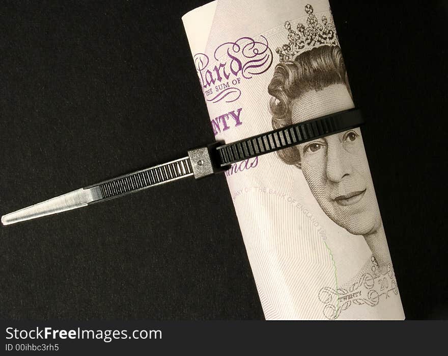 British Pound notes tied with cable strap. British Pound notes tied with cable strap.