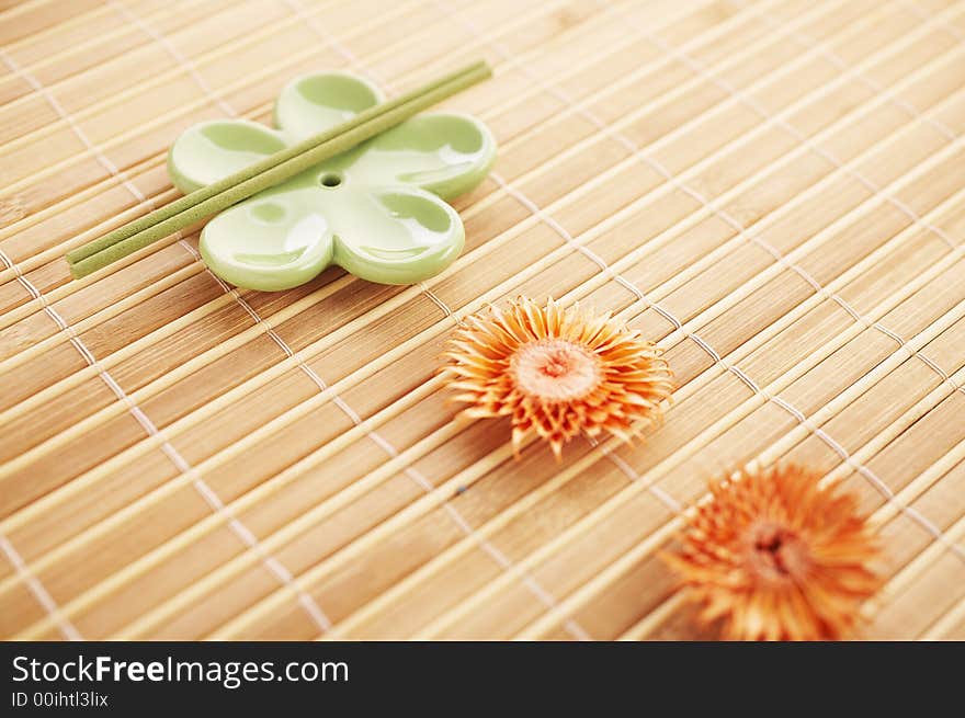 Incense stick on bamboo mat with dried flowers. Incense stick on bamboo mat with dried flowers