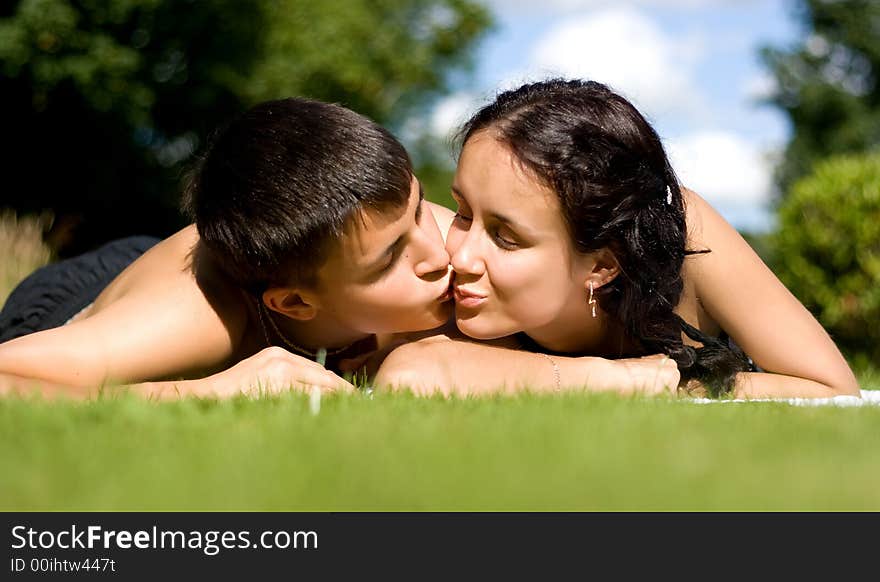 Happy couple lying on grass.