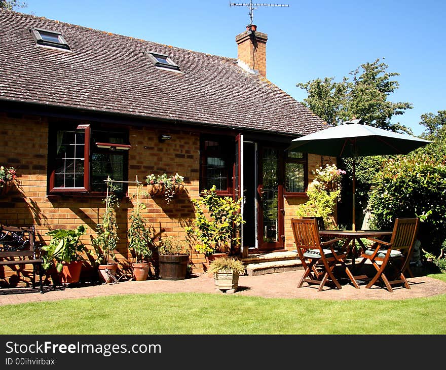 Outside Dining area with Table and Chairs and Parasol in a back garden in England. Outside Dining area with Table and Chairs and Parasol in a back garden in England