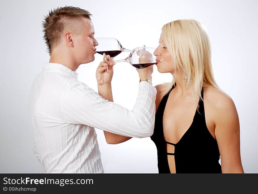 Happy young couple celebrating - drinking red wine