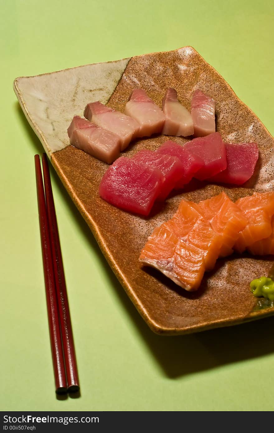 A plate of sashimi on green background