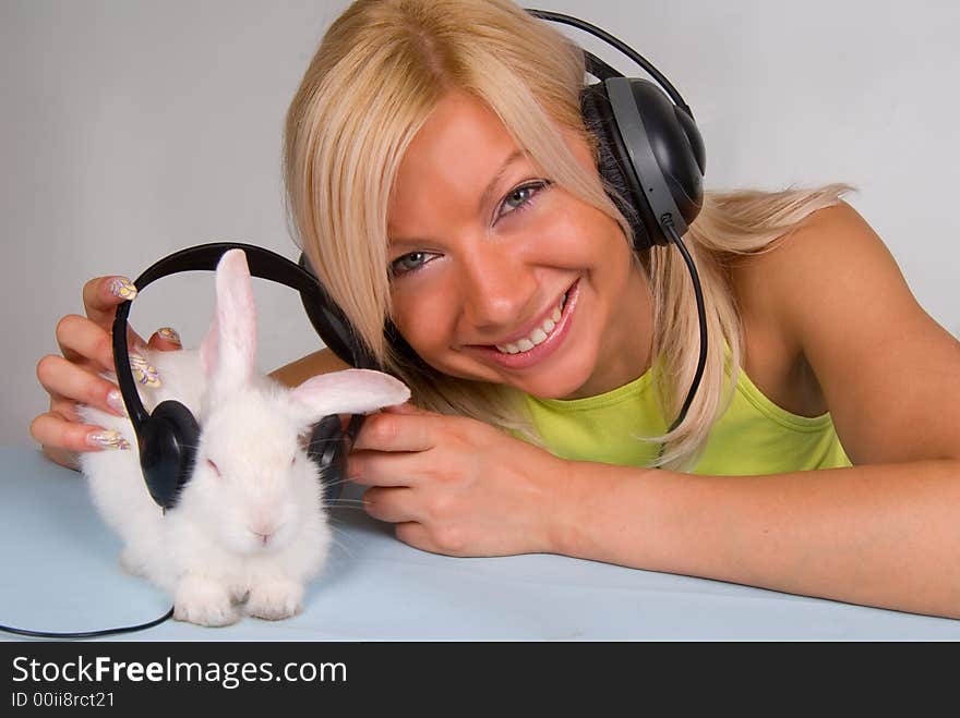 Cute blond and white rabbit listening to music. Cute blond and white rabbit listening to music