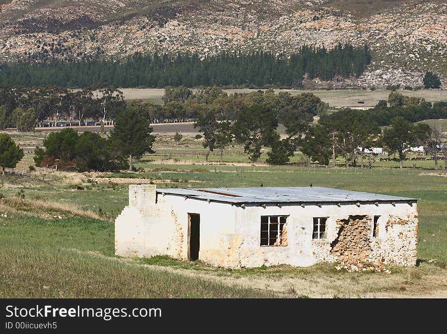 Broken old  house on a farm next to a mountain. Broken old  house on a farm next to a mountain