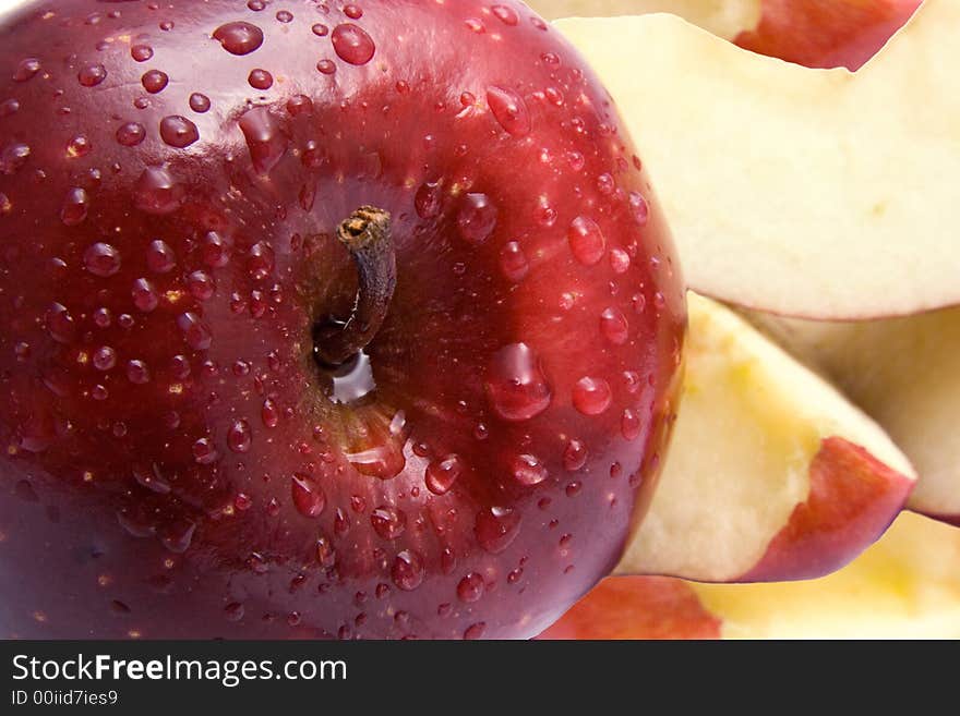 Close-up of a red delicious apple with slices in the background.