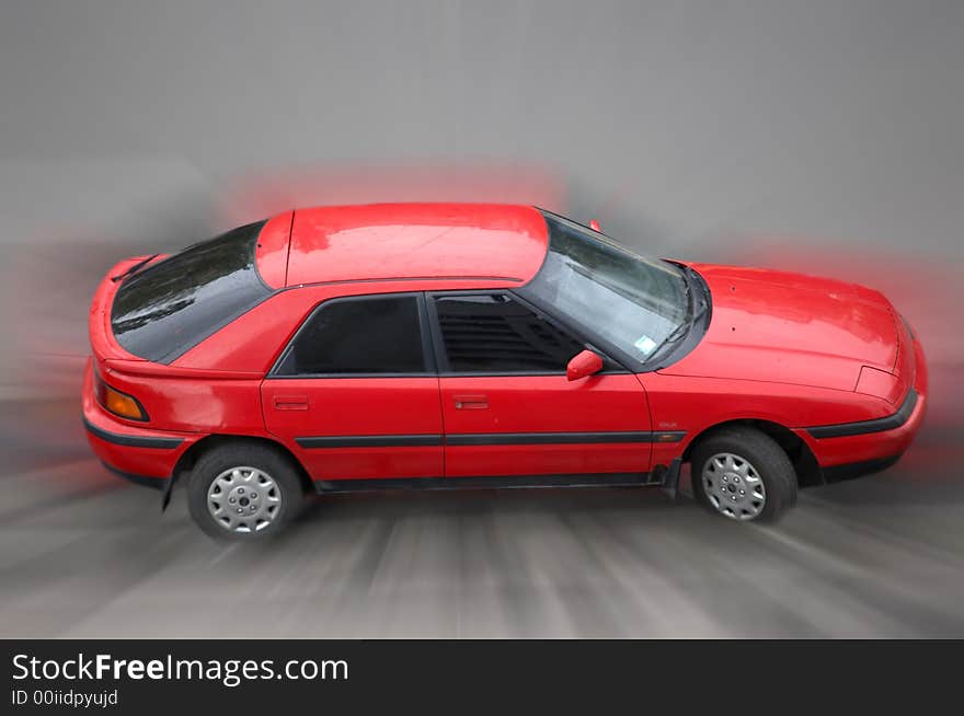 The image of the red car in movement. The image of the red car in movement