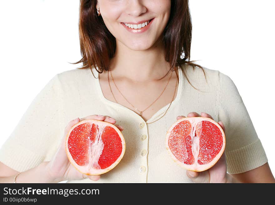 The beautiful girl holds half of grapefruit in hands. The beautiful girl holds half of grapefruit in hands