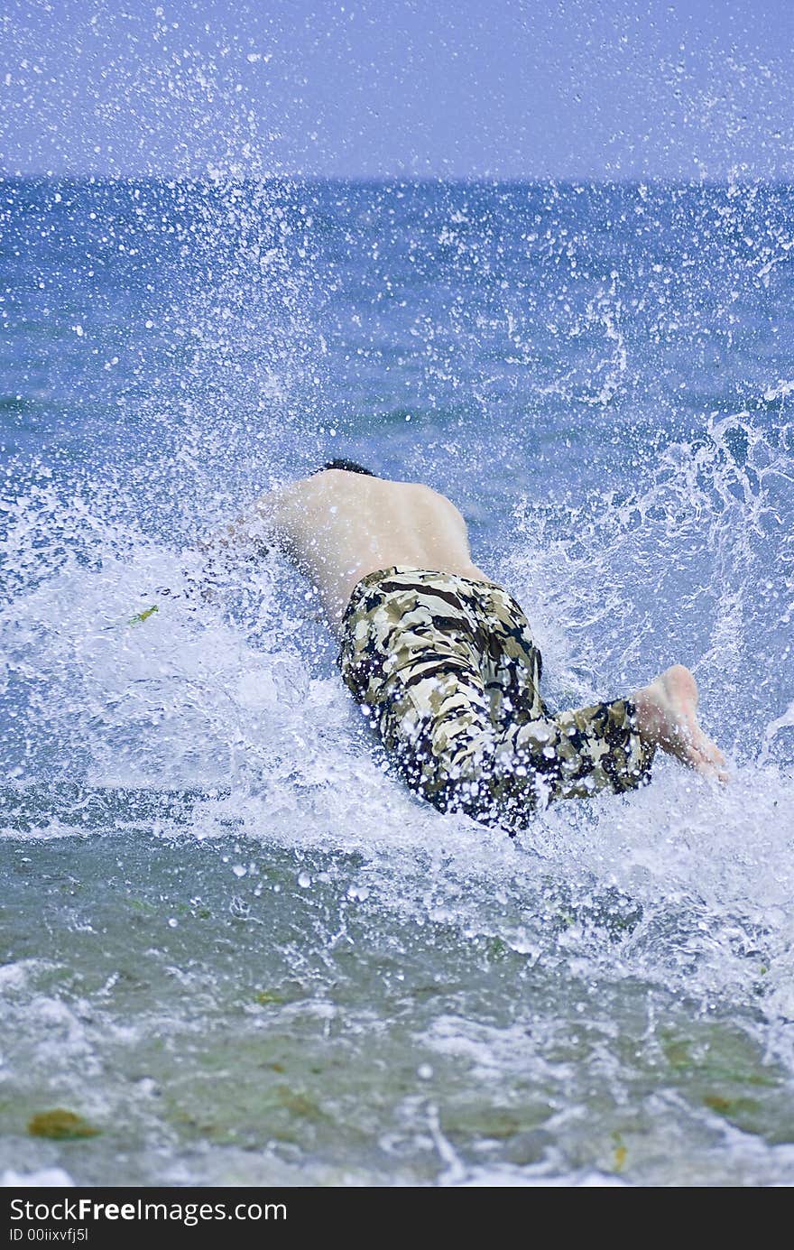 Young man jumping into sea water