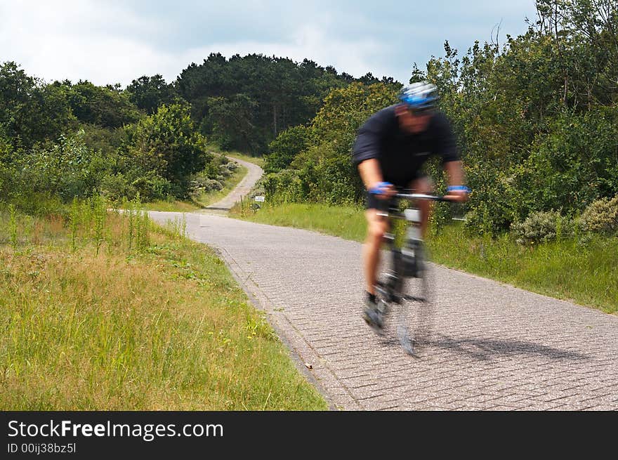 A race cycle (with motion blur) racing though nature. A race cycle (with motion blur) racing though nature.