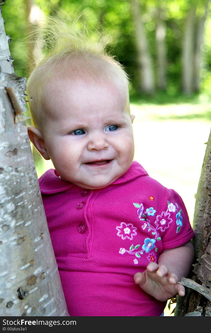 Baby Girl posing next to Tree