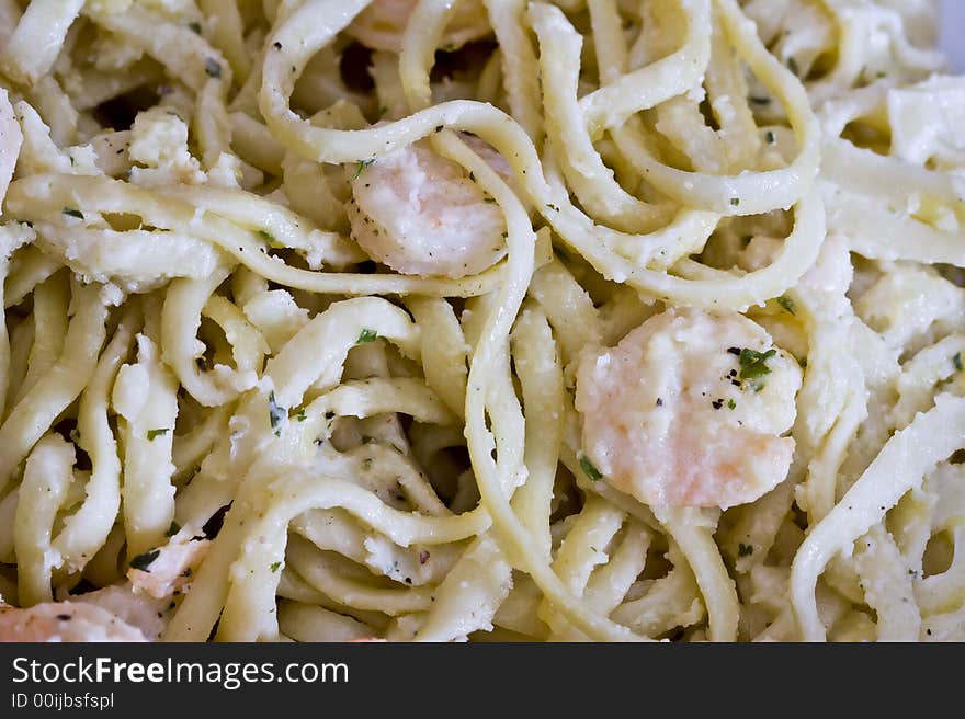 White plate full of shrimp pasta seasoned and hot. White plate full of shrimp pasta seasoned and hot