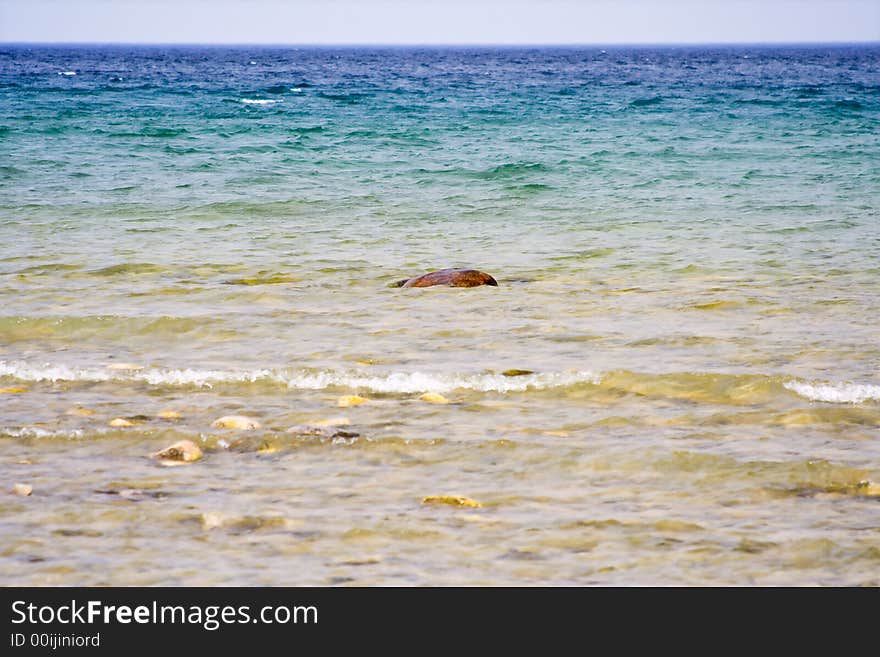 Landscape shot of lake huron on the beach bright blue colors rocks in the foreground. Landscape shot of lake huron on the beach bright blue colors rocks in the foreground